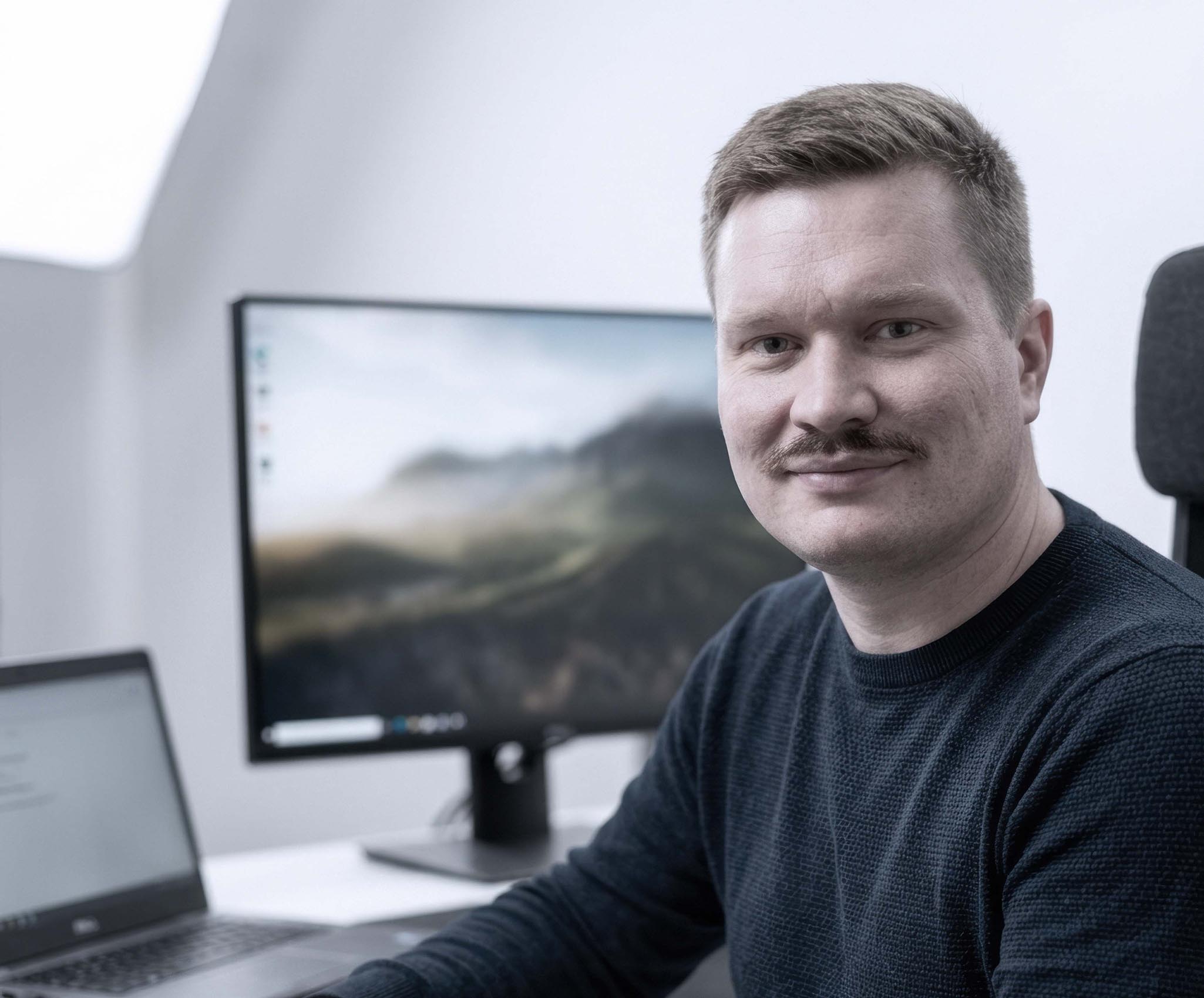 Portret van engineer van ILITAS met scherm in moderne werkomgeving