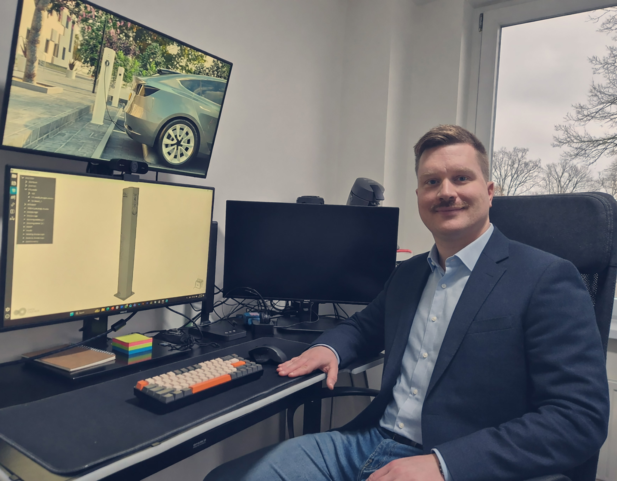 werktuigbouwkundig engineer aan bureau met 3D CAD ontwerp van EV laadpaal op scherm